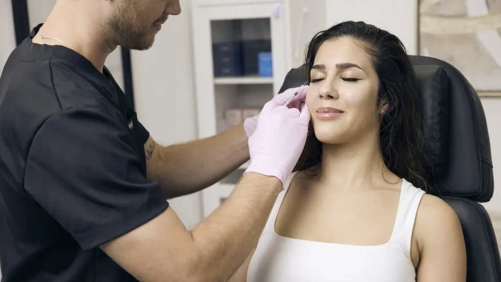 Injector mapping Botox treatment areas during a consultation at Spoiled Aesthetics