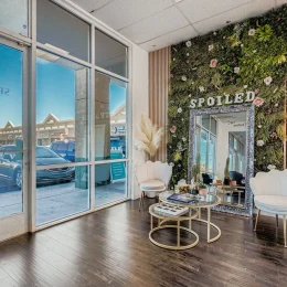 Med spa lobby with green floral wall and Spoiled signage