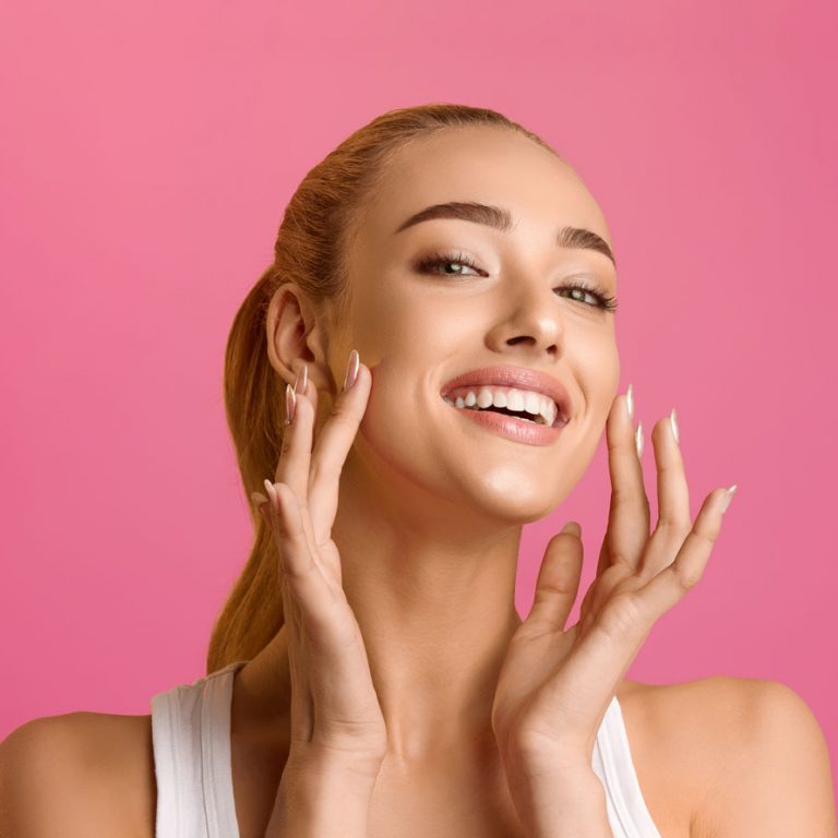 Happy woman with glowing skin after facial treatment